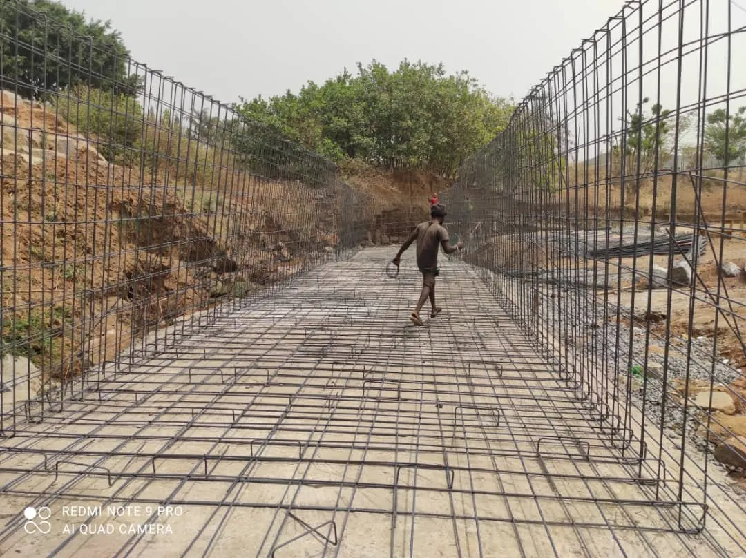 Reinforcement for a concrete channel floor and walls laid along an eroded gully