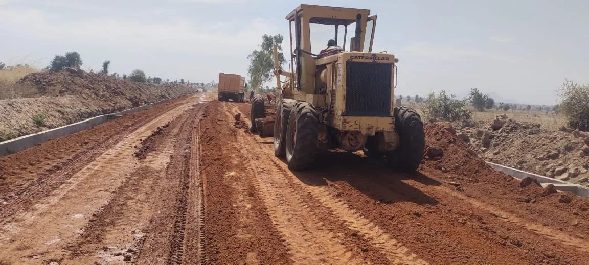 Grader levelling the laterite road base