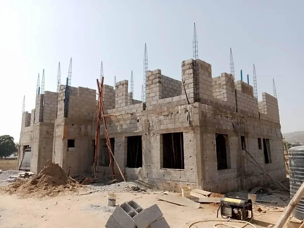 Two-storey blockwork shell with column reinforcement standing above roof level