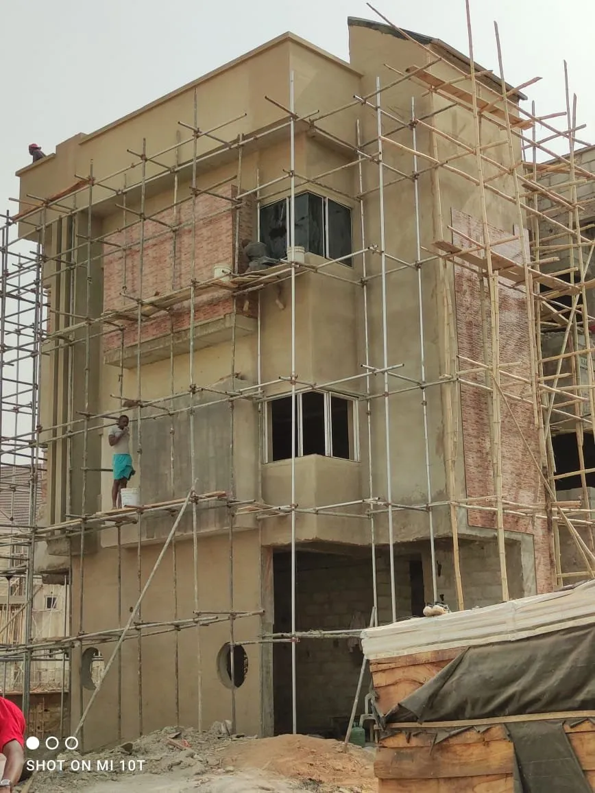 A worker on the scaffolding applying finishes to the facade