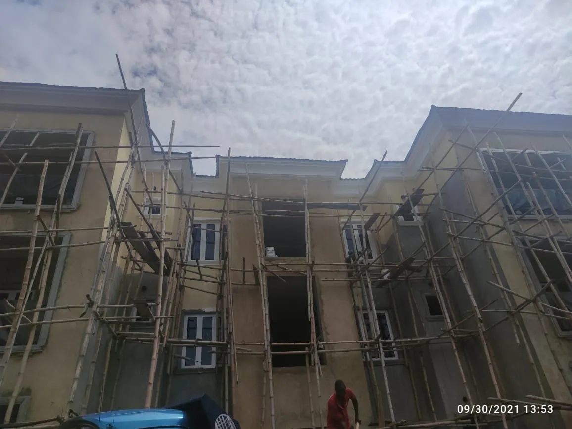Wide view of the block from below, scaffolding along the full facade