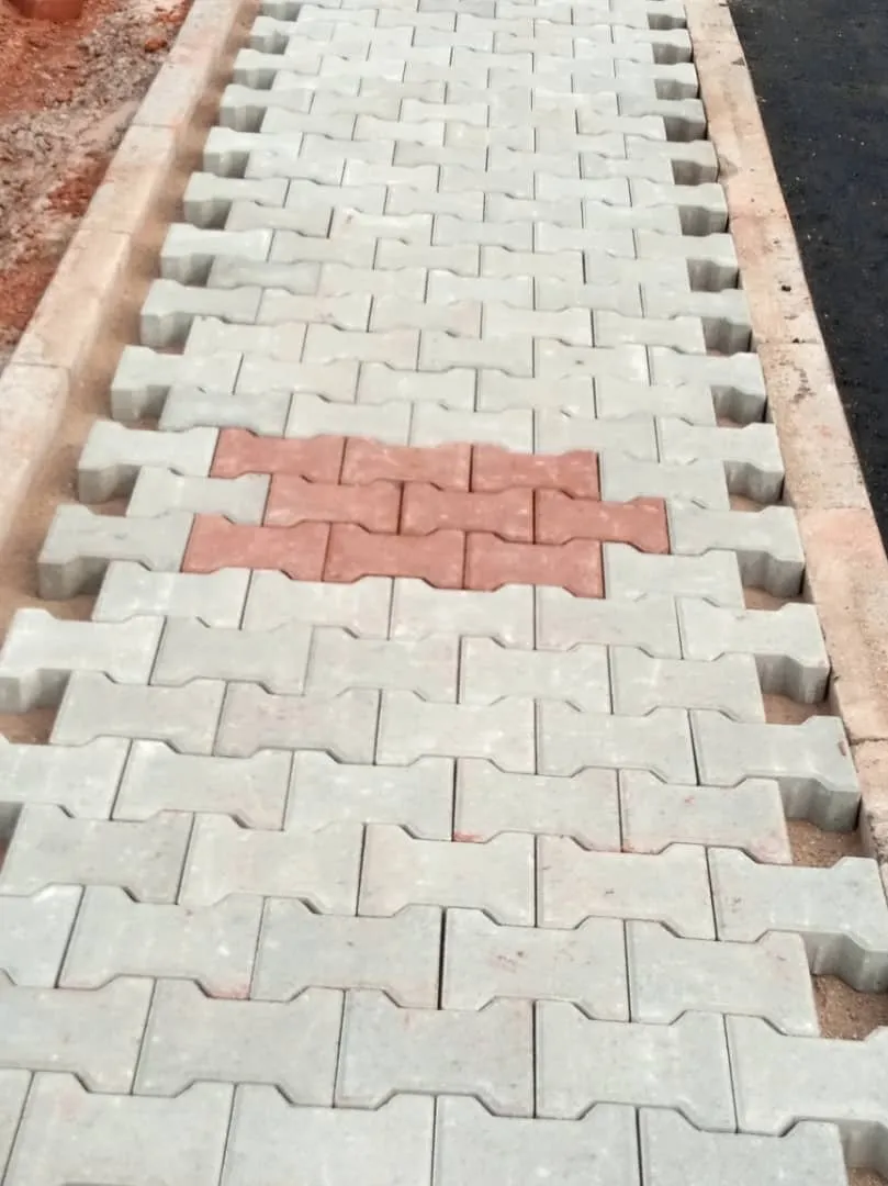 Interlocking concrete paving with a red pattern laid between kerbs