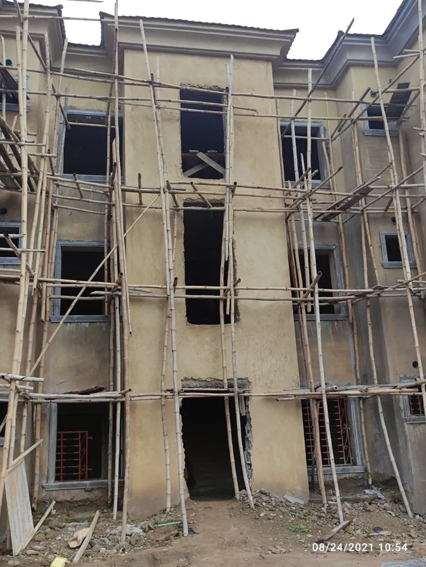 Rendered facade with window openings not yet glazed, scaffolding in front